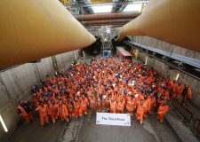 Entire tunnel team celebrating achievement of milestone in front of tunnel portal